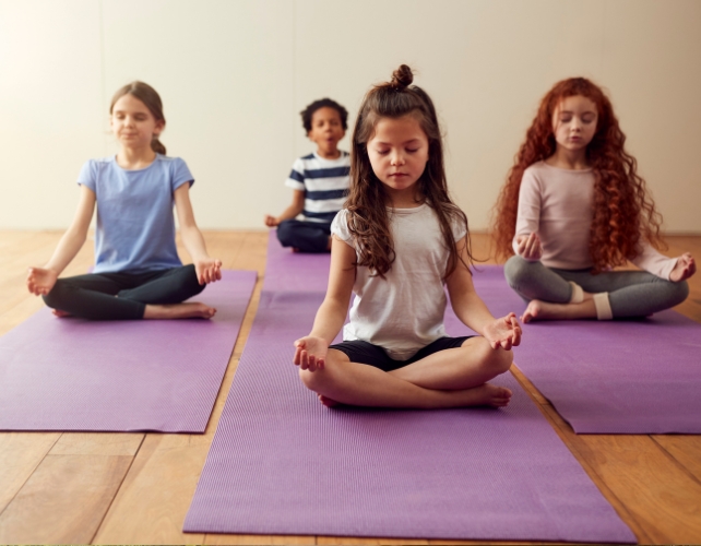 Children on yoga mats with legs crossed