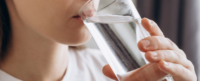 woman drinking water from a glass