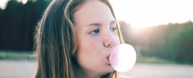 girl blowing a bubble with gum