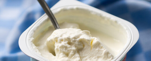 closeup photo of strained yogurt in container with spoon